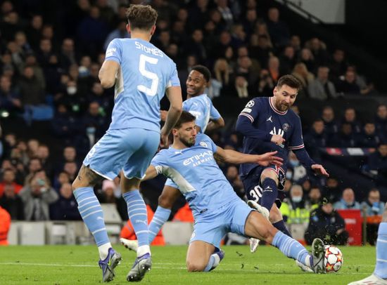 Zawodnik Paris Saint-Germain oddaje strzał, blokowany przez piłkarza Manchesteru City podczas meczu.